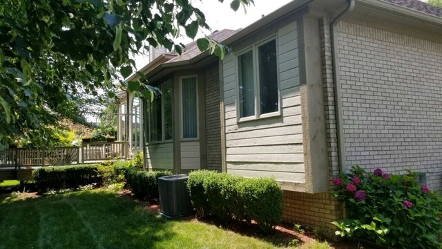 48280 Elmwood Dr, Shelby Twp, MI 48315 - view of home's exterior with central AC unit, brick siding, a yard, and a deck
