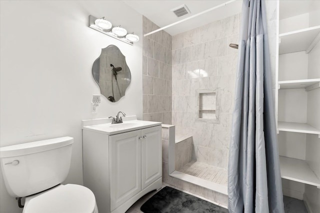 bathroom featuring vanity, toilet, and walk in shower