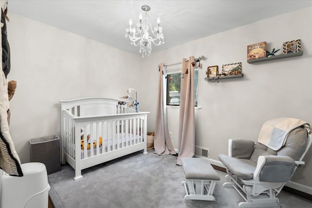 carpeted bedroom with a nursery area and a notable chandelier