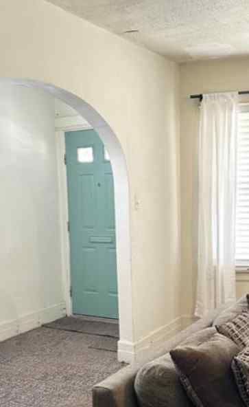 carpeted foyer with a textured ceiling