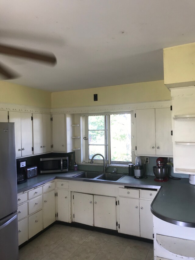 8620 Scio Church Rd, Ann Arbor, MI 48103 - kitchen with stainless steel appliances, a sink, dark countertops, white cabinetry, and light tile patterned flooring