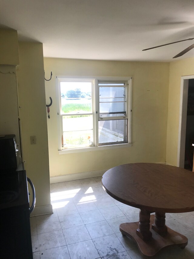 8620 Scio Church Rd, Ann Arbor, MI 48103 - dining space with a ceiling fan, light tile patterned floors, and baseboards