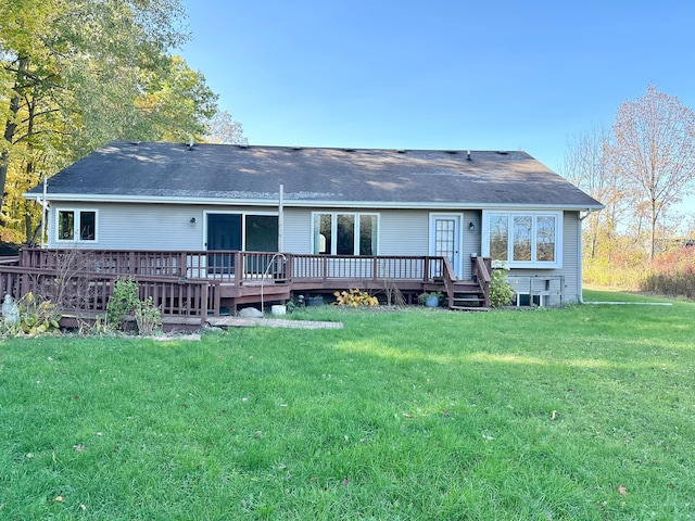 rear view of property with a deck and a lawn