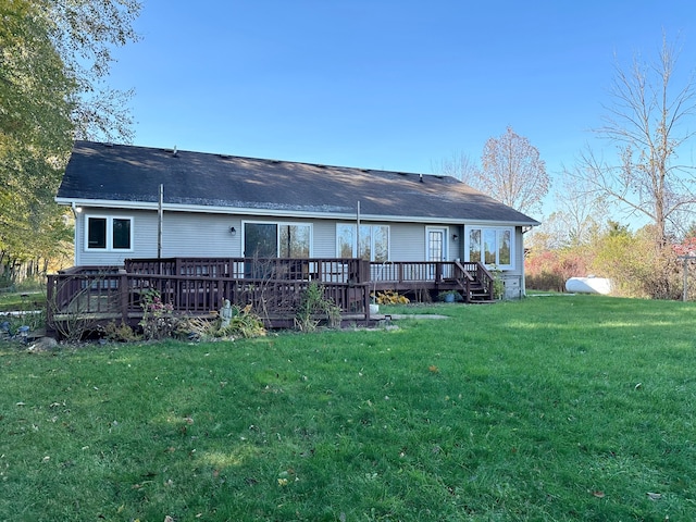 rear view of property with a yard and a wooden deck