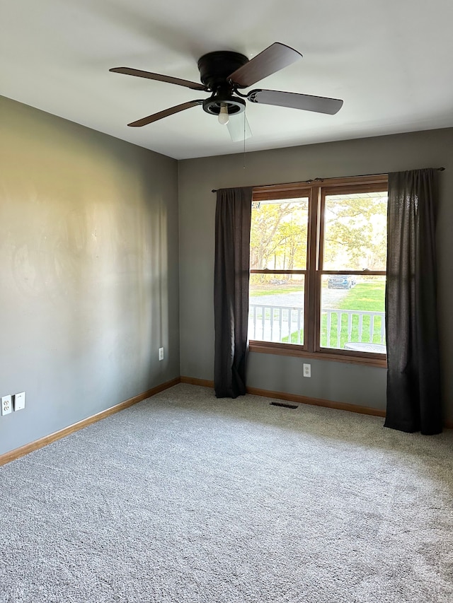 carpeted empty room featuring ceiling fan