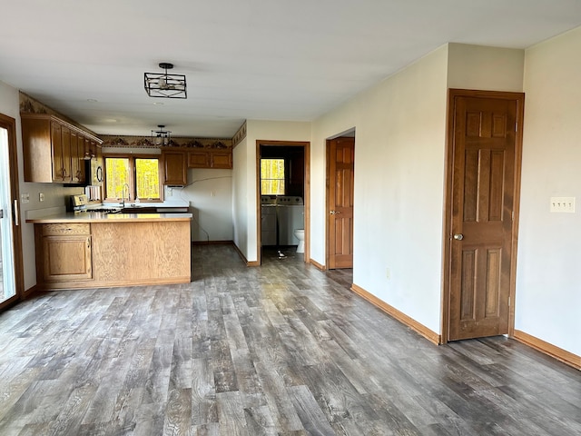 kitchen featuring kitchen peninsula, sink, and dark hardwood / wood-style floors