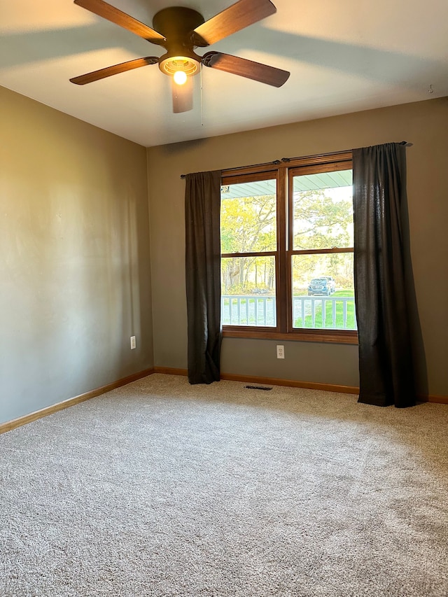 carpeted spare room featuring ceiling fan