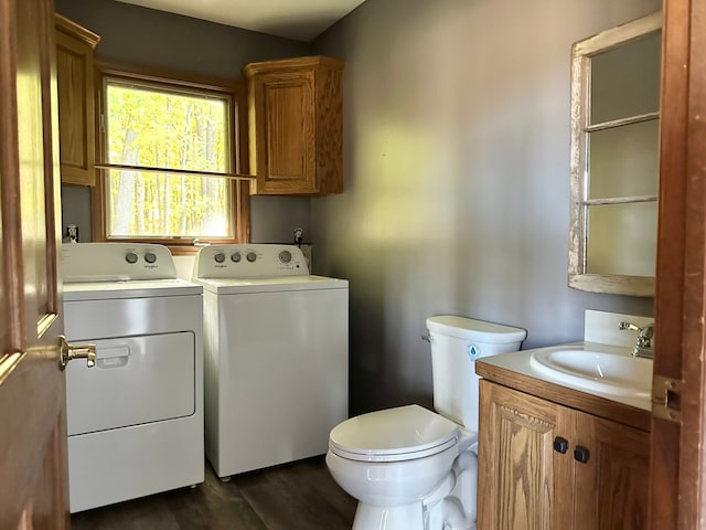 laundry room with sink, washer and dryer, and dark hardwood / wood-style floors