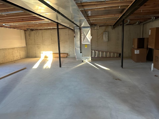 basement featuring heating unit and electric panel