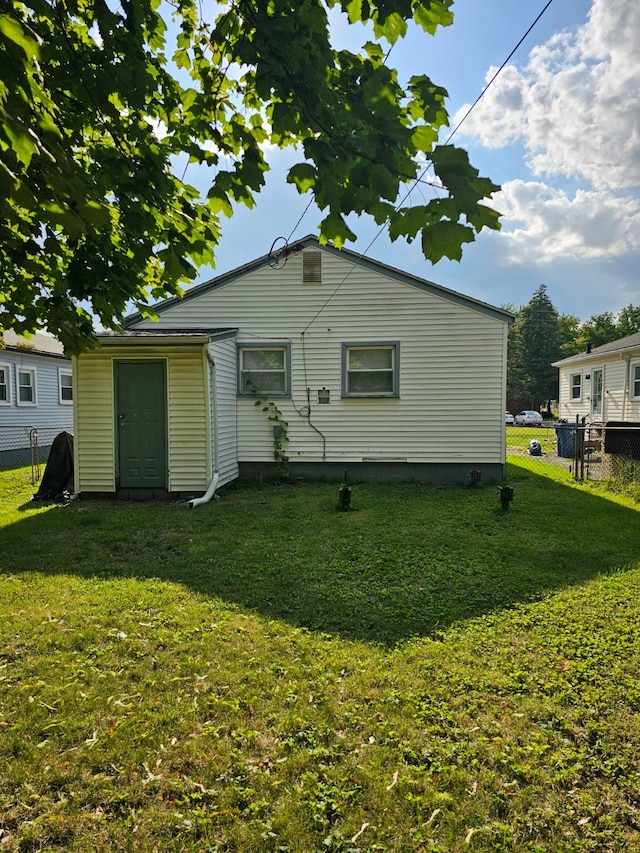 rear view of house featuring a lawn