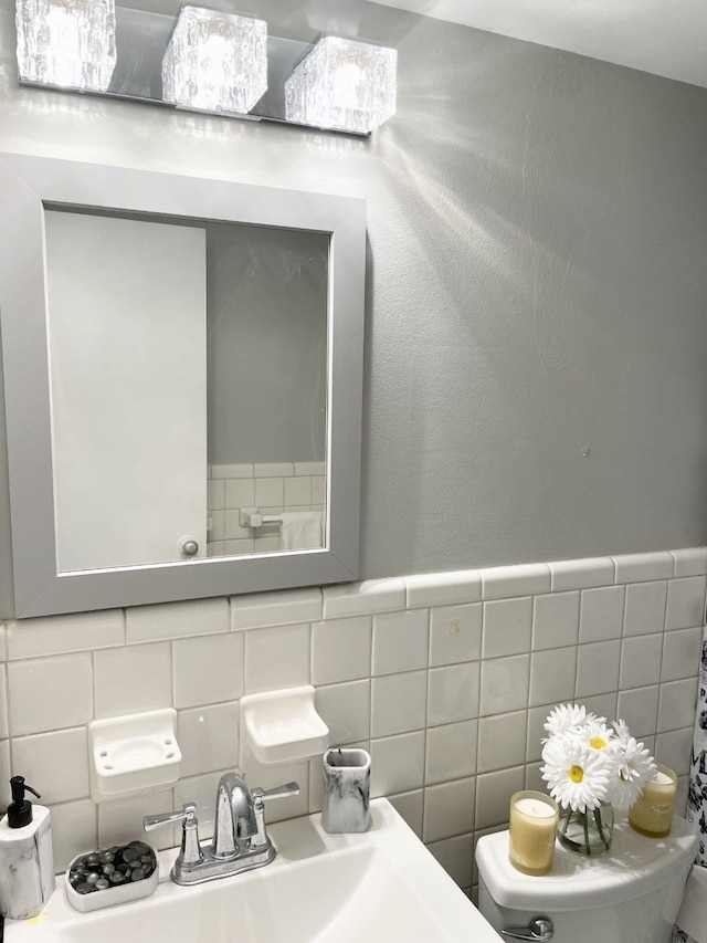 bathroom featuring sink and tile walls