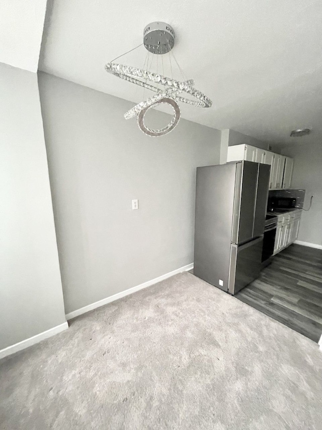 kitchen featuring white cabinets, stainless steel fridge, and carpet flooring