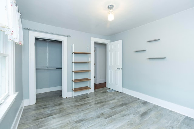 unfurnished bedroom featuring light hardwood / wood-style flooring and a closet