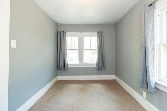 carpeted empty room with a textured ceiling