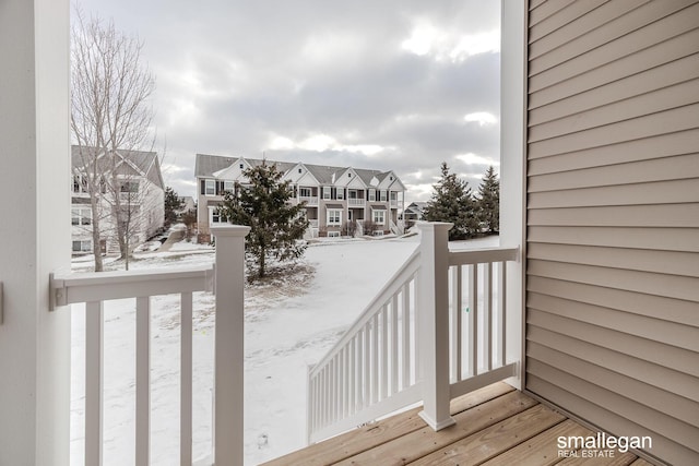 snow covered deck with a residential view