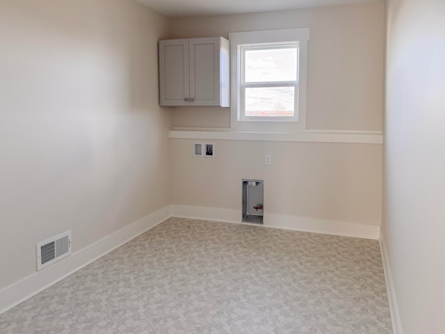 clothes washing area with cabinets and washer hookup