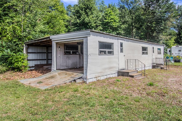 view of outdoor structure with a carport and a lawn