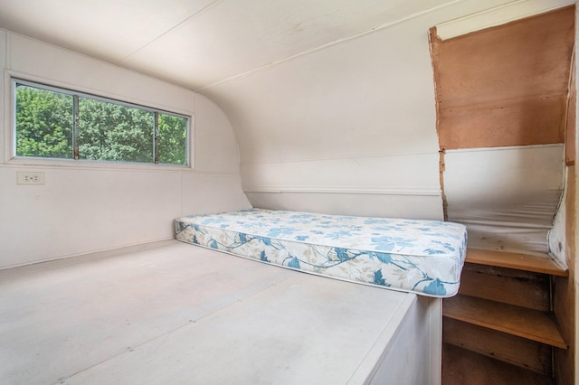 bedroom with concrete floors and vaulted ceiling