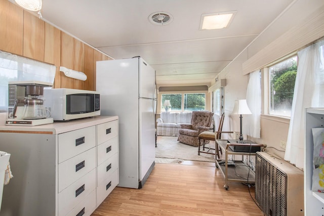 kitchen featuring light wood-type flooring and white appliances