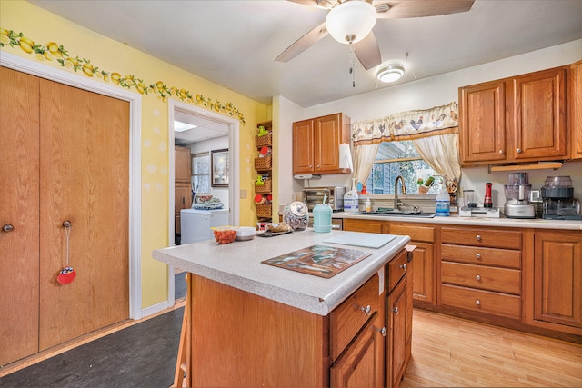 kitchen featuring ceiling fan, a center island, light hardwood / wood-style floors, and sink