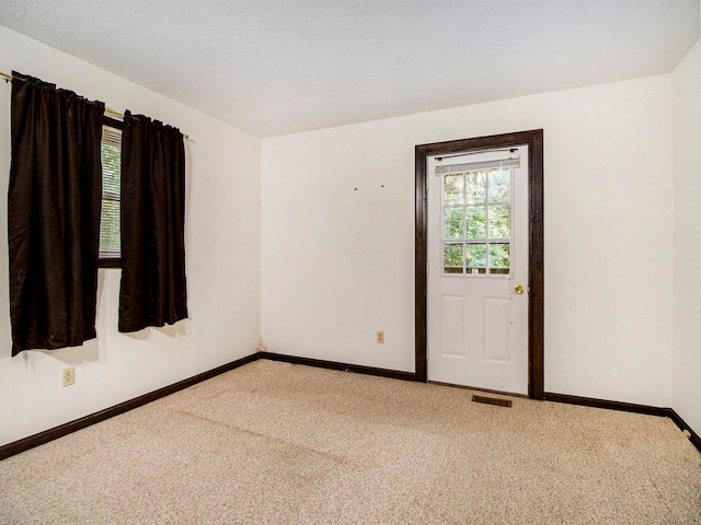 carpeted spare room with a textured ceiling