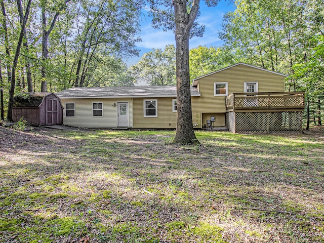 back of house featuring a storage unit and a wooden deck