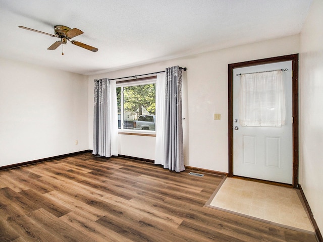 entrance foyer featuring a textured ceiling, ceiling fan, and dark hardwood / wood-style floors