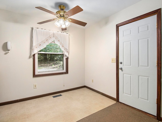 spare room featuring light colored carpet and ceiling fan