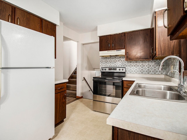 kitchen featuring stainless steel electric range oven, sink, tasteful backsplash, white fridge, and dark brown cabinets