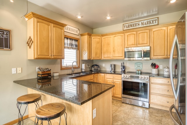 kitchen featuring kitchen peninsula, a kitchen breakfast bar, stainless steel appliances, and sink