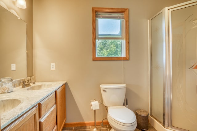 bathroom with tile patterned floors, vanity, toilet, and a shower with door