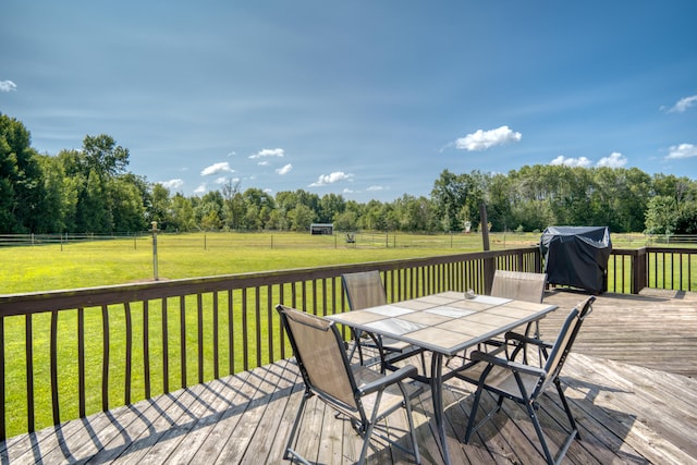 wooden deck with area for grilling, a yard, and a rural view