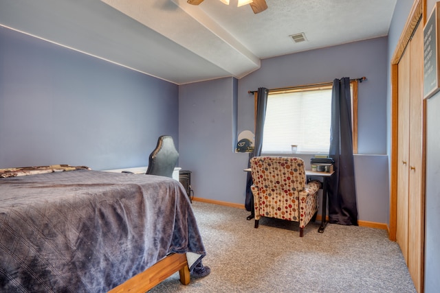 carpeted bedroom featuring ceiling fan, vaulted ceiling, a textured ceiling, and a closet