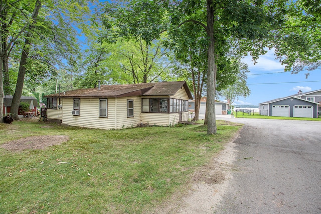 ranch-style house featuring an outbuilding, a garage, and a front lawn