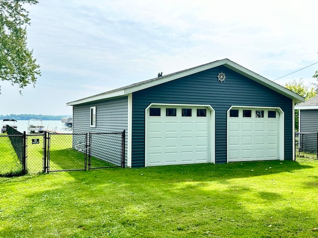 garage featuring a lawn and a water view