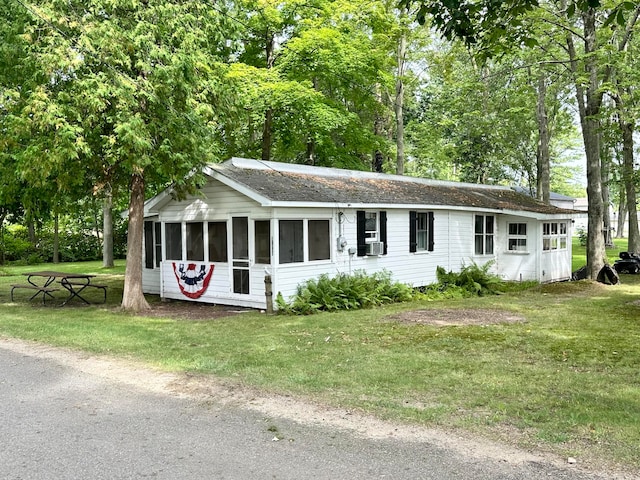 ranch-style house featuring cooling unit and a front yard