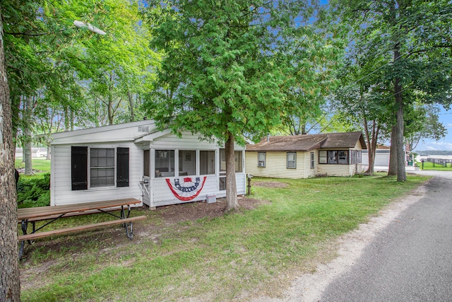 view of front of house with a front lawn and an outdoor structure