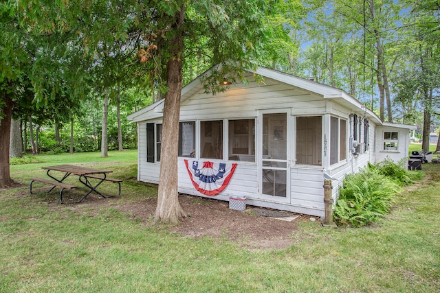 view of front of property featuring a sunroom and a front lawn