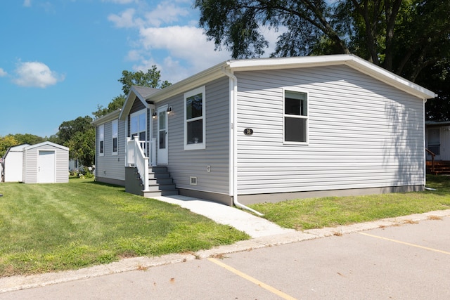 view of front of home featuring a front lawn and a storage shed