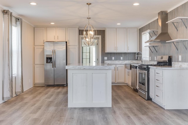 645 N Gallery Dr Unit 98, Eaton Rapids, MI 48827 - kitchen with appliances with stainless steel finishes, wall chimney exhaust hood, a chandelier, a kitchen island, and light wood-style floors