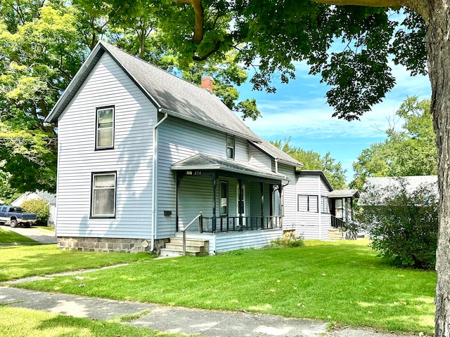 rear view of property with a yard and a porch