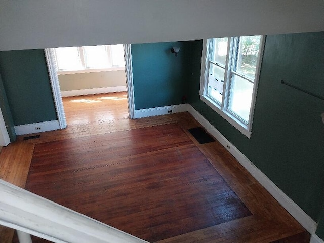 empty room featuring dark hardwood / wood-style flooring and a wealth of natural light