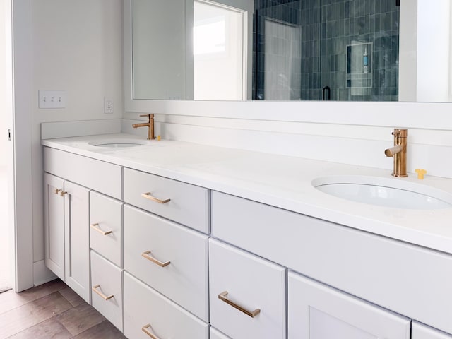 bathroom featuring a shower with door and vanity