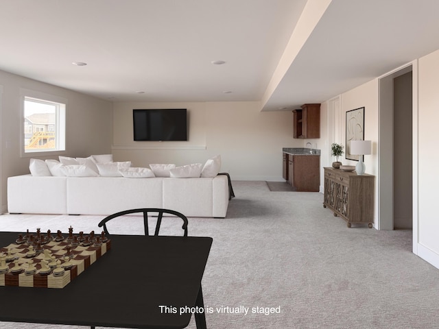 living area featuring light colored carpet and baseboards