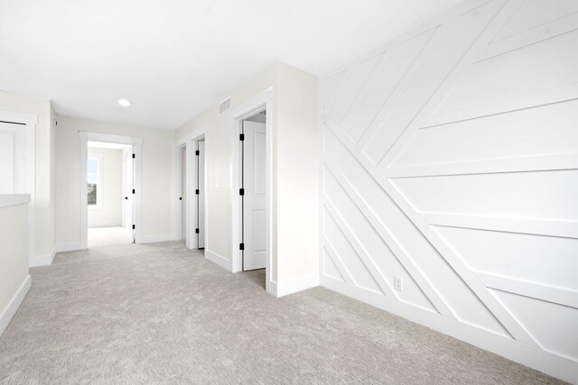 hallway with light carpet, baseboards, and recessed lighting