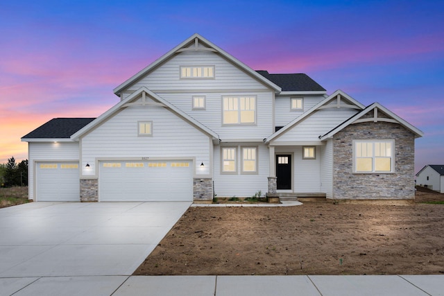 view of front of home featuring stone siding and concrete driveway