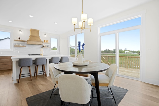 dining space featuring light wood-style floors, a chandelier, recessed lighting, and baseboards