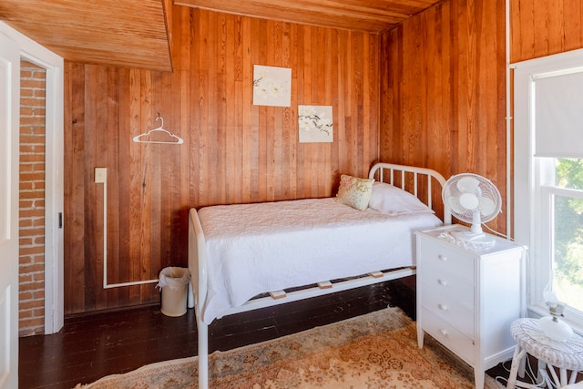 bedroom featuring wood walls, dark wood-type flooring, and wooden ceiling