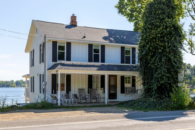 view of front of house with a porch and a water view