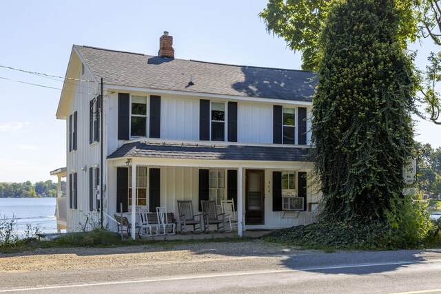 976 Doster Rd, Plainwell, MI 49080 - view of front of home featuring covered porch, a chimney, a shingled roof, board and batten siding, and a water view